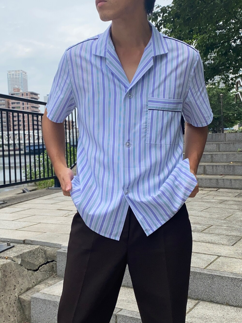 ブルー系のシャツ/ブラウス、ブラウン系のパンツ、ブラウン系のシューズを着用したメンズの夏コーディネートの2枚目の写真