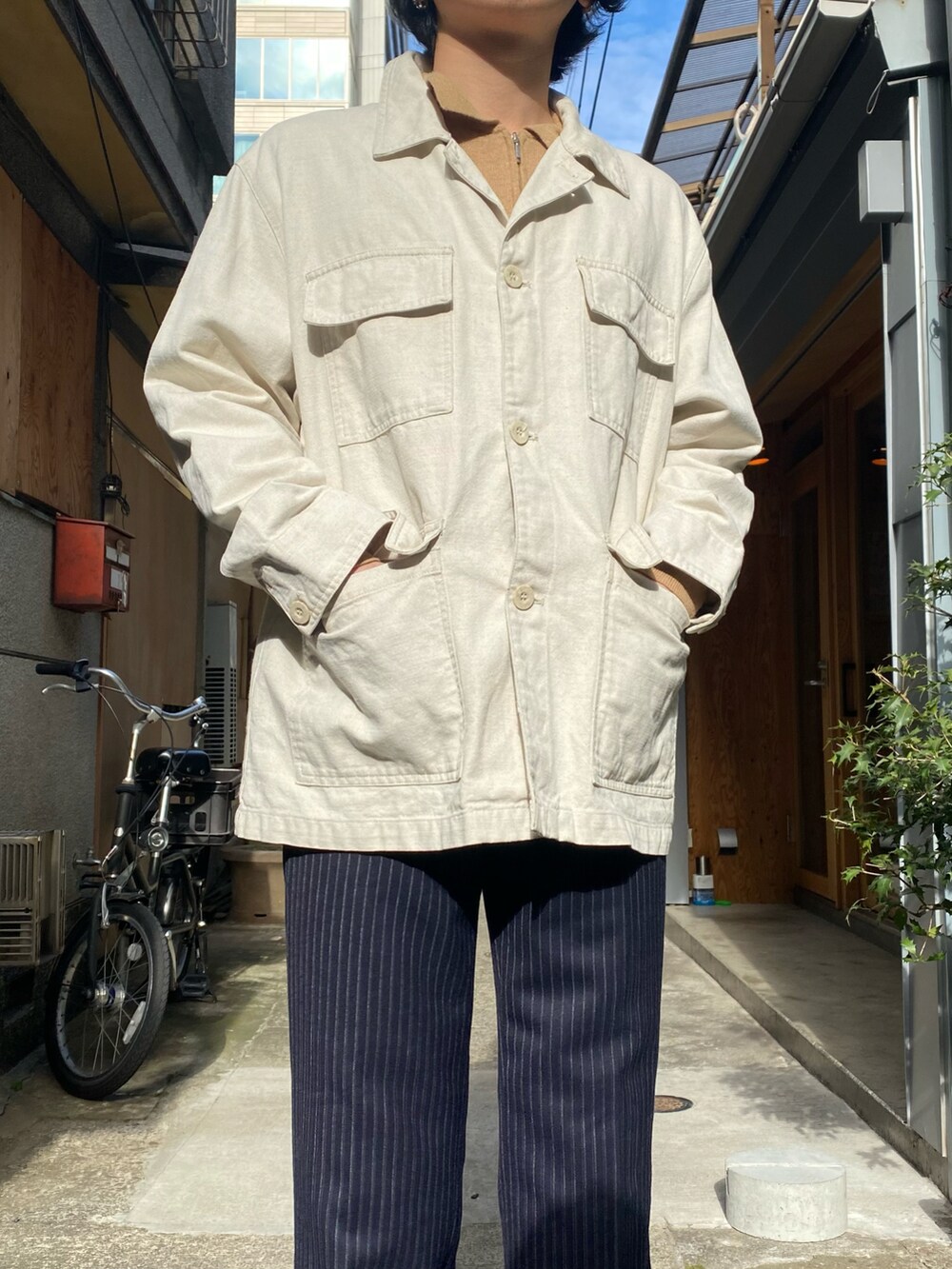 ベージュ系のジャケット/アウター、ブルー系のスラックス、ブラウン系のシューズを着用したメンズの冬コーディネートの2枚目の写真
