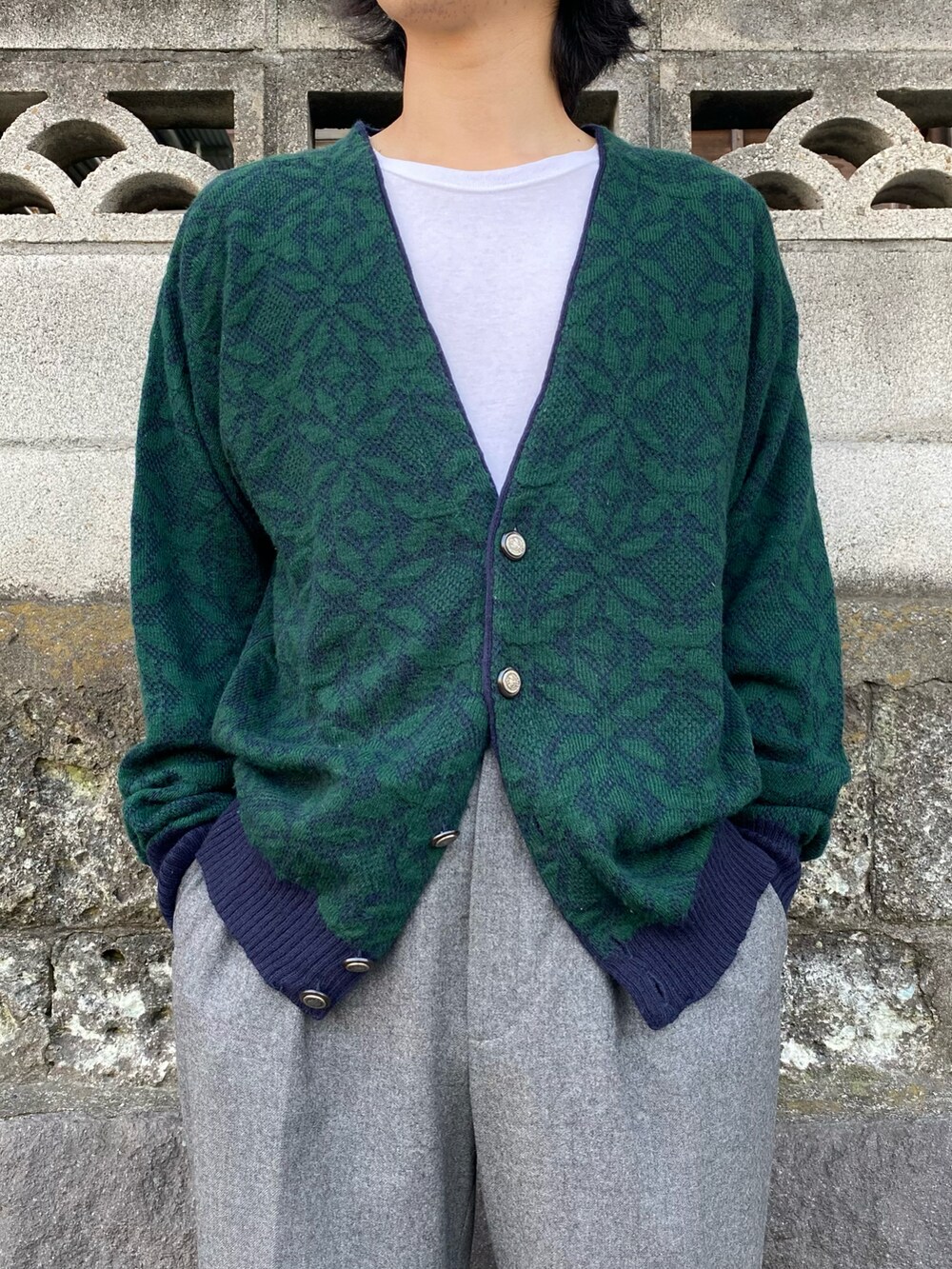 グリーン系のカーディガン/ボレロ、グレー系のスラックス、ブラウン系のシューズを着用したメンズの春コーディネートの3枚目の写真