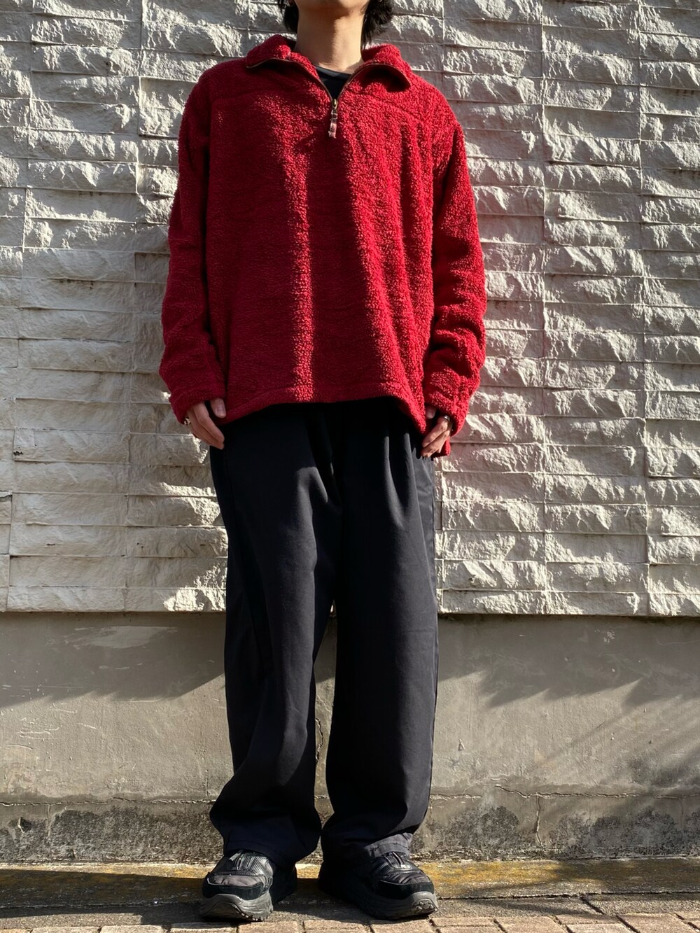 レッド系のトップス、ブラック系のスニーカーを着用したメンズの冬コーディネートの2枚目の写真