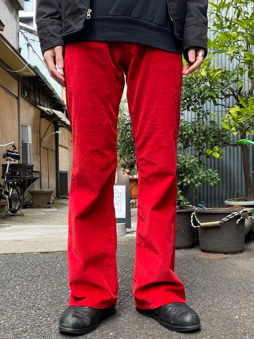 ブラック系のジャケット/アウター、ブラック系のスウェット、レッド系のパンツを着用したメンズの冬コーディネートの2枚目の写真