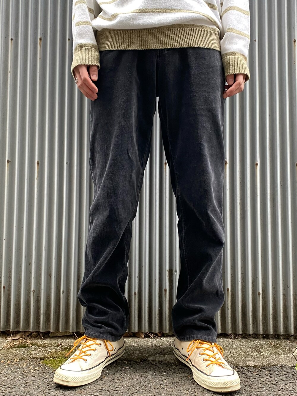 ホワイト系のニット/セーター、ブラック系のパンツ、イエロー系のスニーカーを着用したメンズの春コーディネートの3枚目の写真