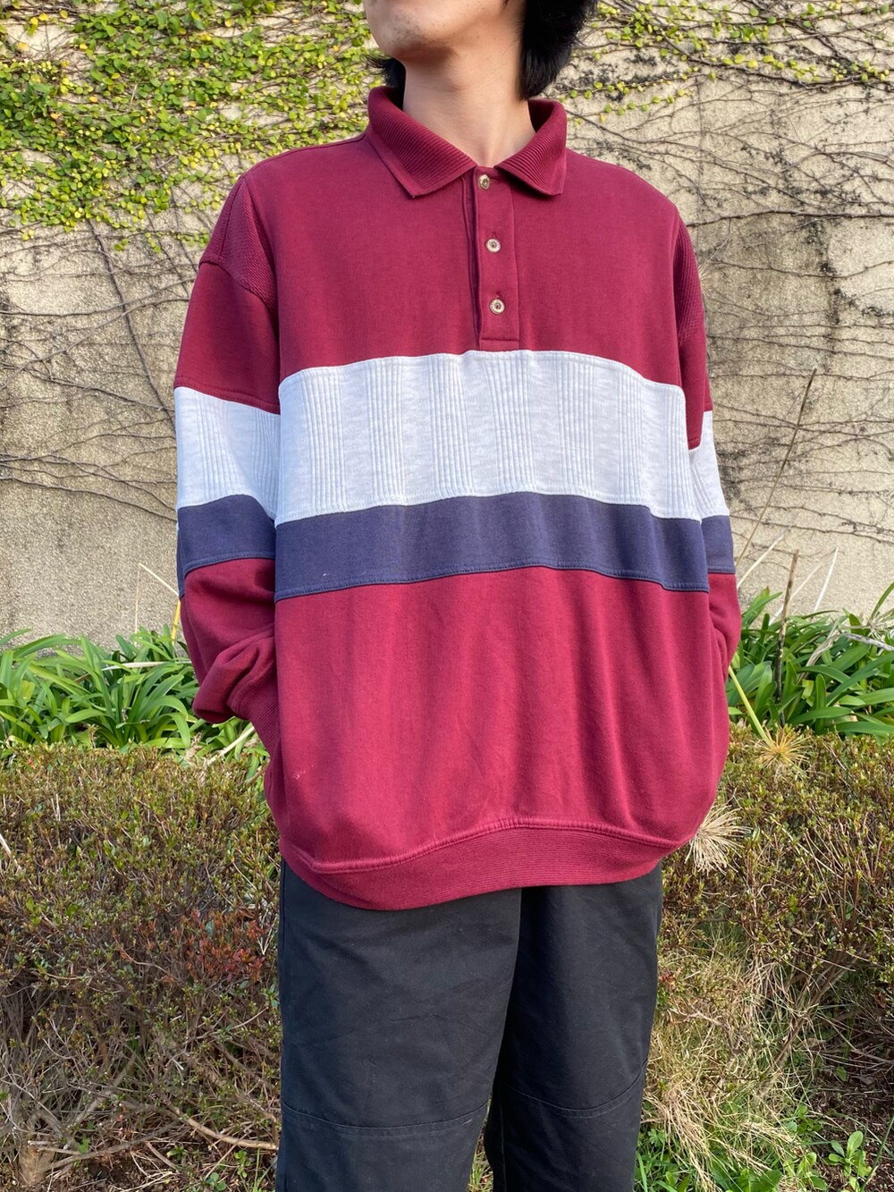 レッド系のスウェット、ブラック系のスニーカーを着用したメンズの春コーディネートの2枚目の写真