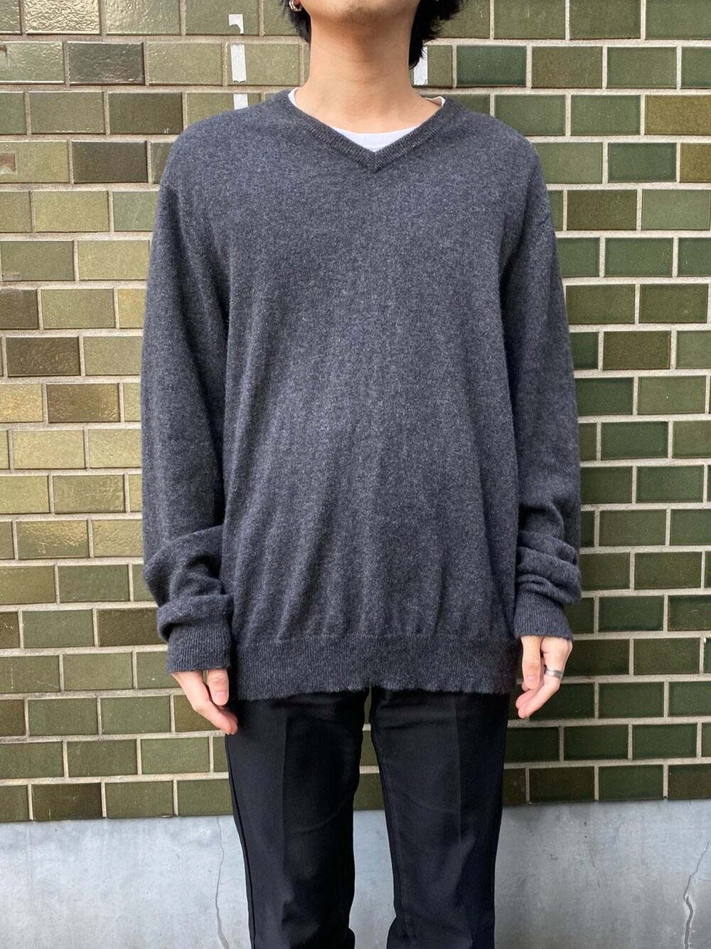 ブラック系のスラックス、ブラック系のスニーカー、ブラック系のニット/セーターを着用したメンズの冬コーディネートの4枚目の写真