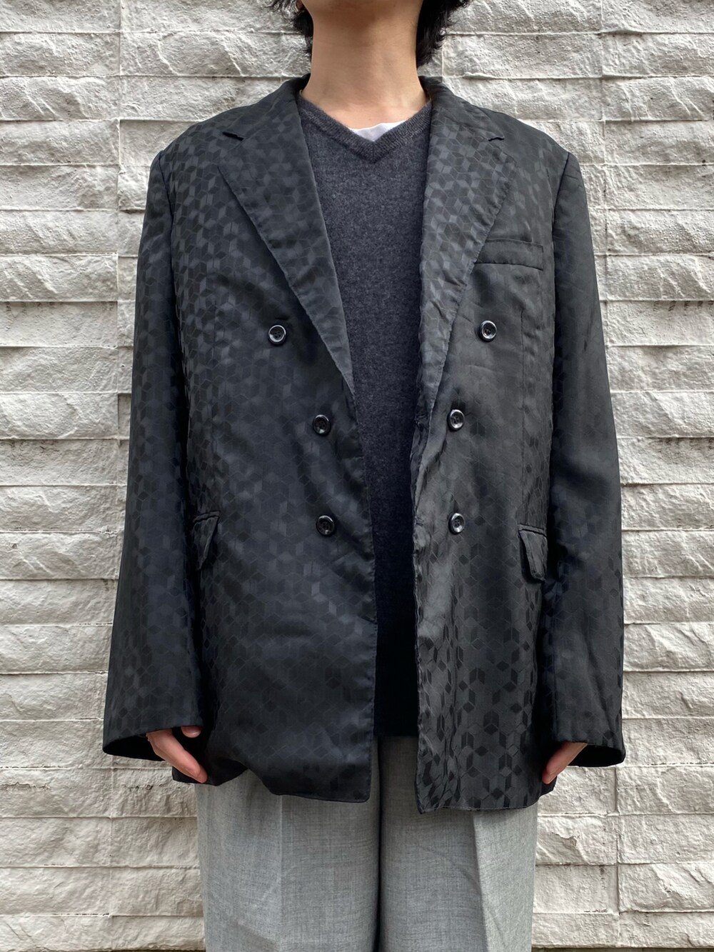 ブラック系のテーラードジャケット、グレー系のスラックス、ブラック系のスニーカーを着用したメンズの冬コーディネートの2枚目の写真