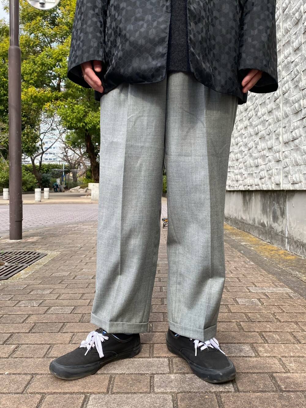 ブラック系のテーラードジャケット、グレー系のスラックス、ブラック系のスニーカーを着用したメンズの冬コーディネートの3枚目の写真