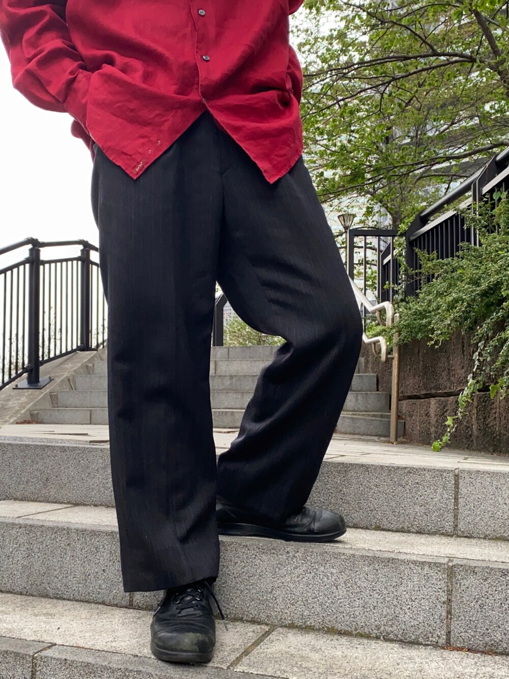 レッド系のシャツ/ブラウス、ブラック系のスラックス、ブラック系のスニーカーを着用したメンズの夏コーディネートの2枚目の写真