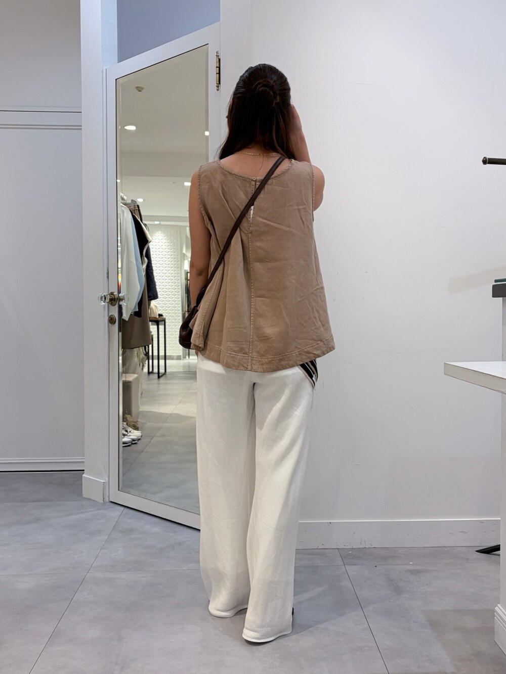 ベージュ系のタンクトップ、ホワイト系のその他パンツ、ブラウン系のショルダーバッグを着用したレディースの夏コーディネートの5枚目の写真