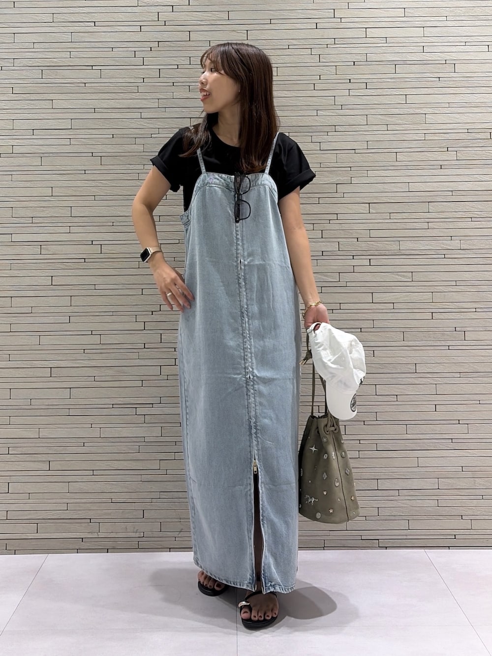 ブルー系のワンピース、グリーン系のショルダーバッグ、ブラック系のTシャツ/カットソーを着用したレディースの夏コーディネートの2枚目の写真