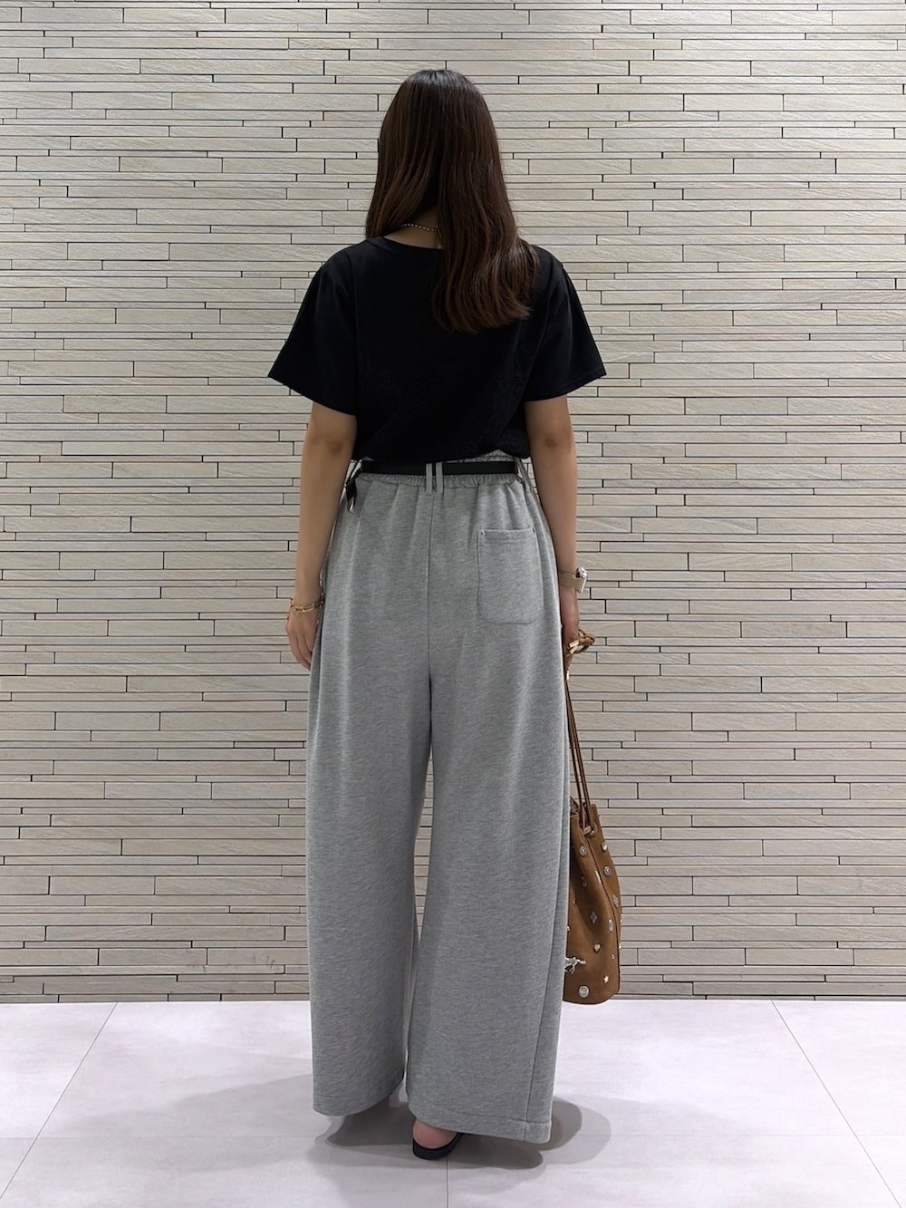 ブラック系のTシャツ/カットソー、イエロー系のショルダーバッグ、グレー系のスウェットパンツを着用したレディースの夏コーディネートの5枚目の写真