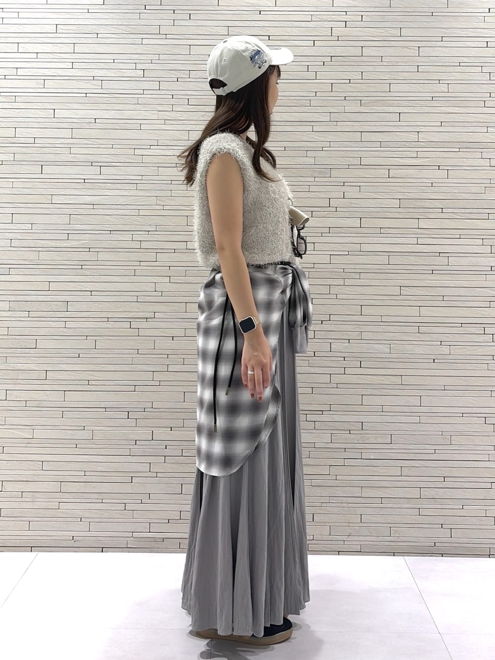 グレー系のスカート、グレー系のシャツ/ブラウス、ベージュ系のニット/セーターを着用したレディースの秋コーディネートの4枚目の写真