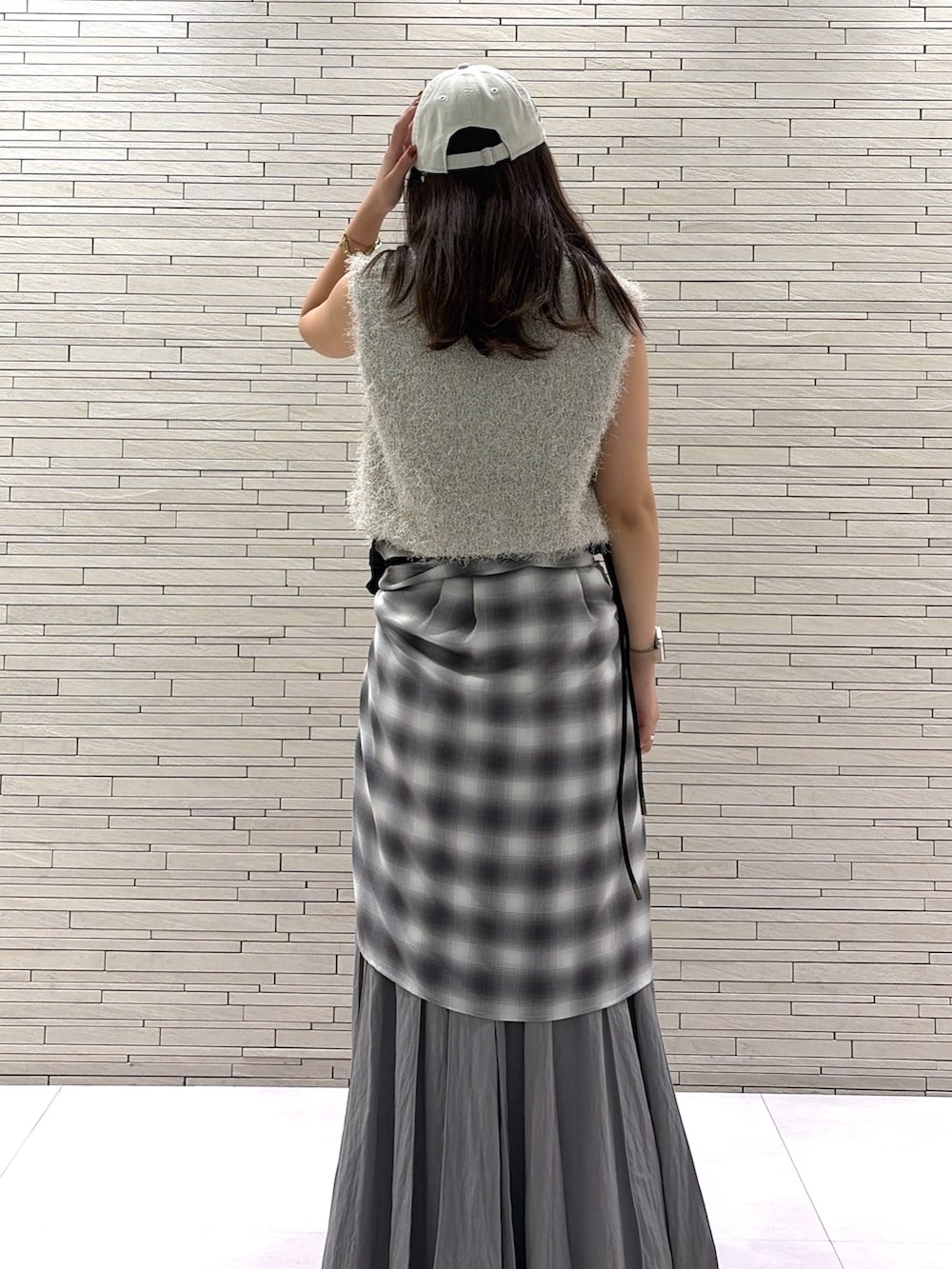 グレー系のスカート、グレー系のシャツ/ブラウス、ベージュ系のニット/セーターを着用したレディースの秋コーディネートの3枚目の写真