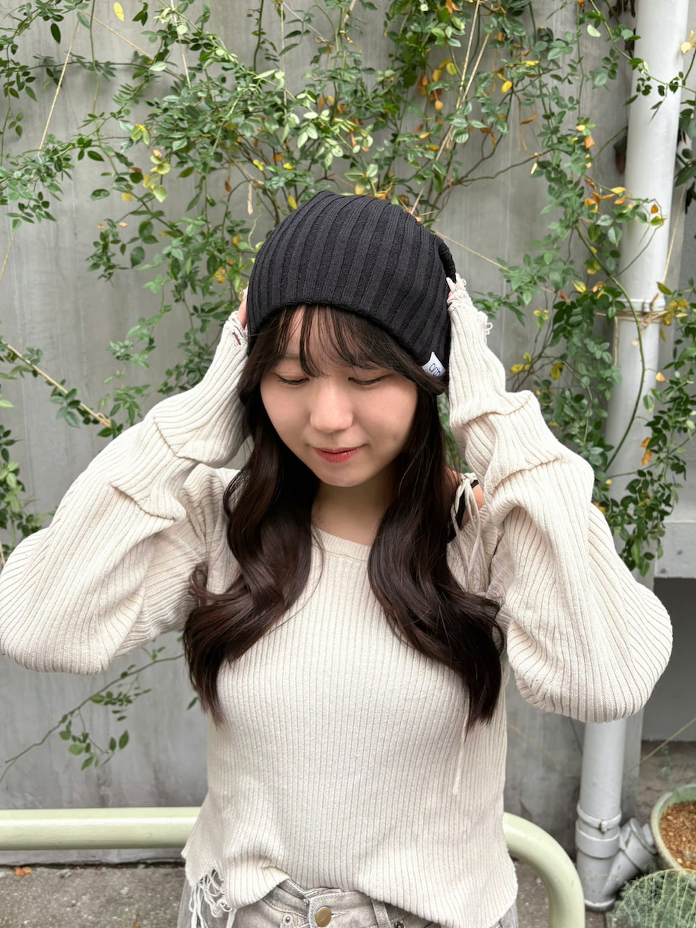 ブラック系のニットキャップ/ビーニーを着用したレディースの秋コーディネートの2枚目の写真