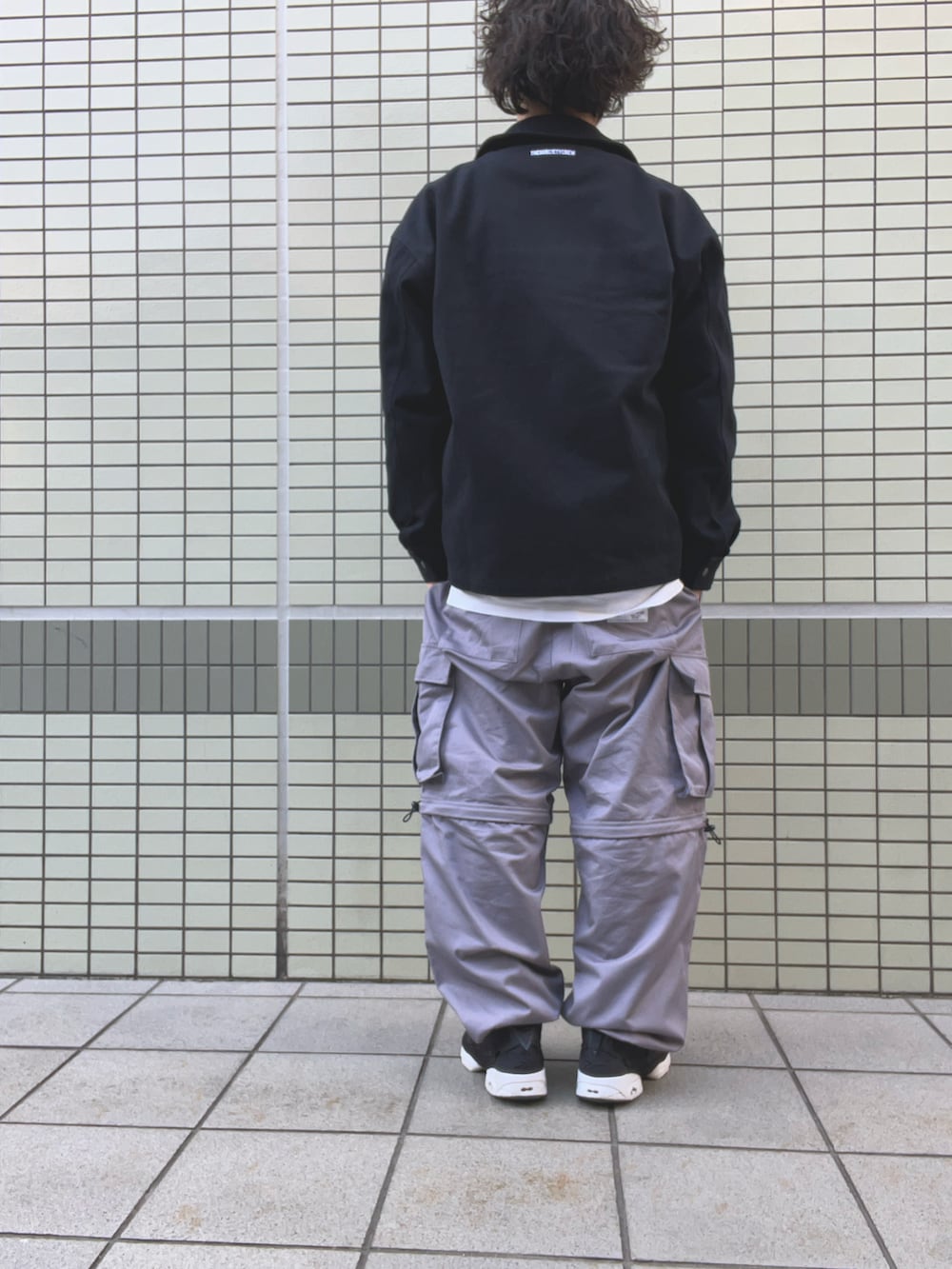 ブラック系のブルゾン、ブラック系のスウェット、ホワイト系のTシャツ/カットソーを着用したメンズの春コーディネートの3枚目の写真