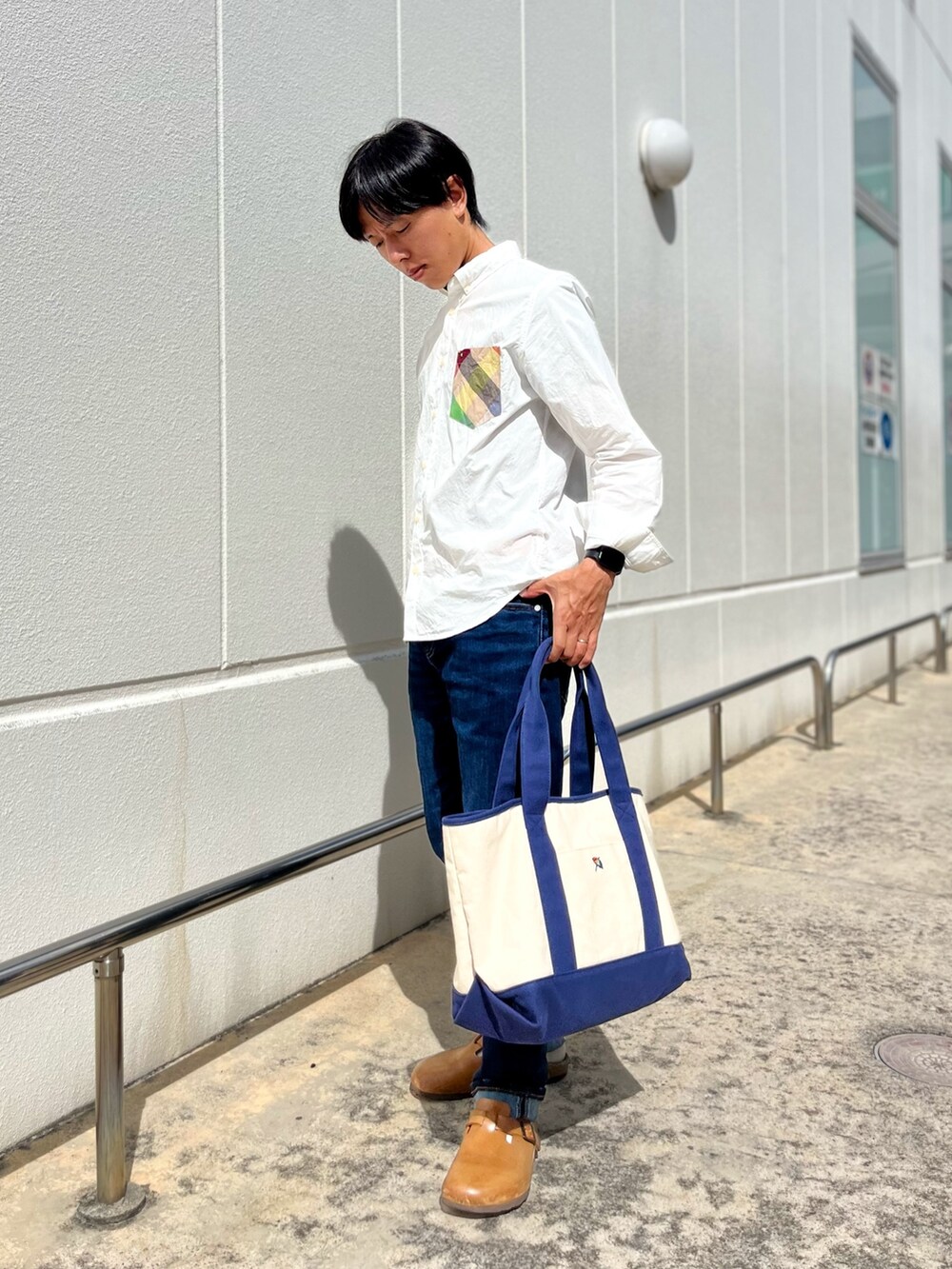 ホワイト系のシャツ/ブラウス、ブルー系のトートバッグ、ブルー系のデニムパンツを着用したメンズの秋コーディネートの2枚目の写真