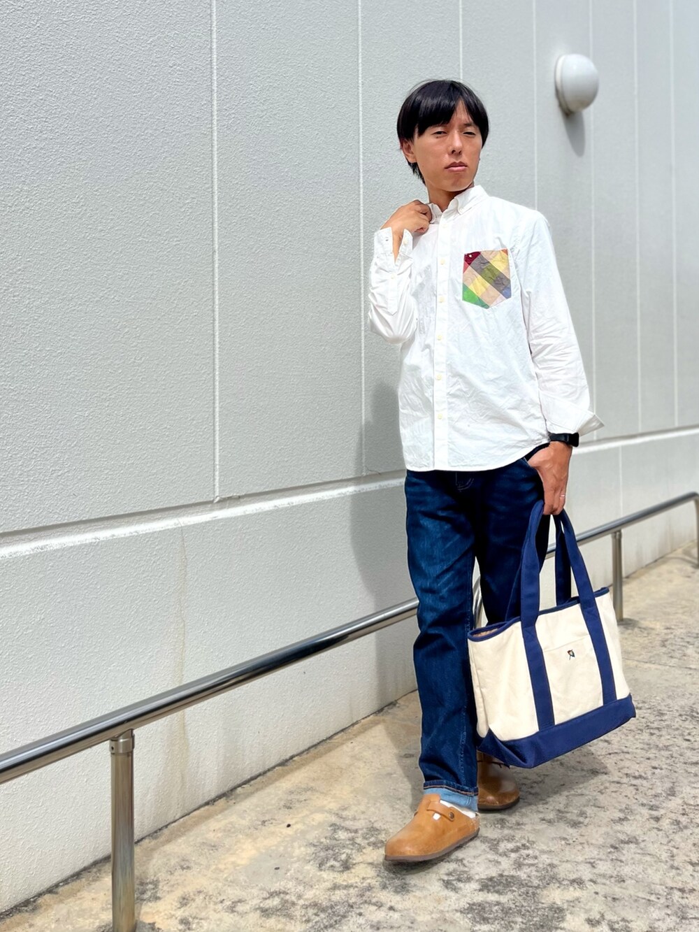 ホワイト系のシャツ/ブラウス、ブルー系のトートバッグ、ブルー系のデニムパンツを着用したメンズの秋コーディネートの4枚目の写真