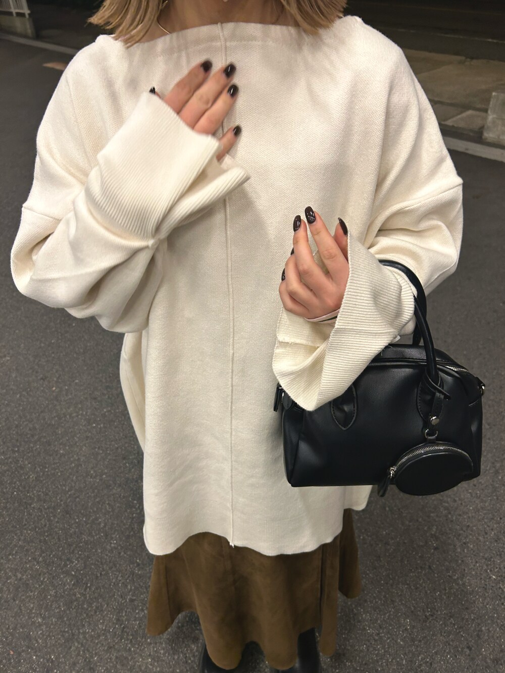ホワイト系のニット/セーター、ブラック系のショルダーバッグ、ブラウン系のスカートを着用したレディースの冬コーディネートの4枚目の写真