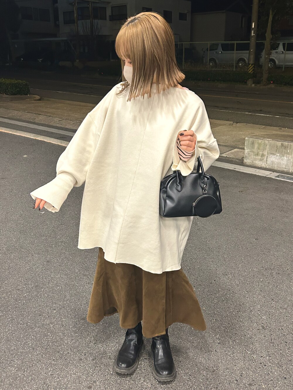 ホワイト系のニット/セーター、ブラック系のショルダーバッグ、ブラウン系のスカートを着用したレディースの冬コーディネートの2枚目の写真