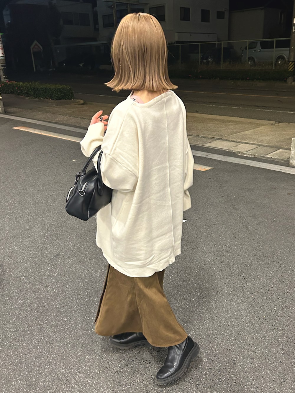 ホワイト系のニット/セーター、ブラック系のショルダーバッグ、ブラウン系のスカートを着用したレディースの冬コーディネートの3枚目の写真