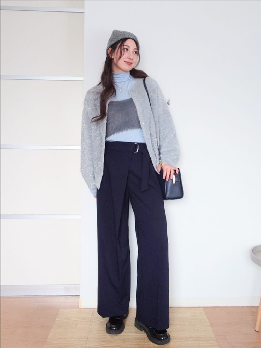 ブルー系のスラックス、グレー系のカーディガン/ボレロ、グレー系のベストを着用したレディースの冬コーディネートの5枚目の写真