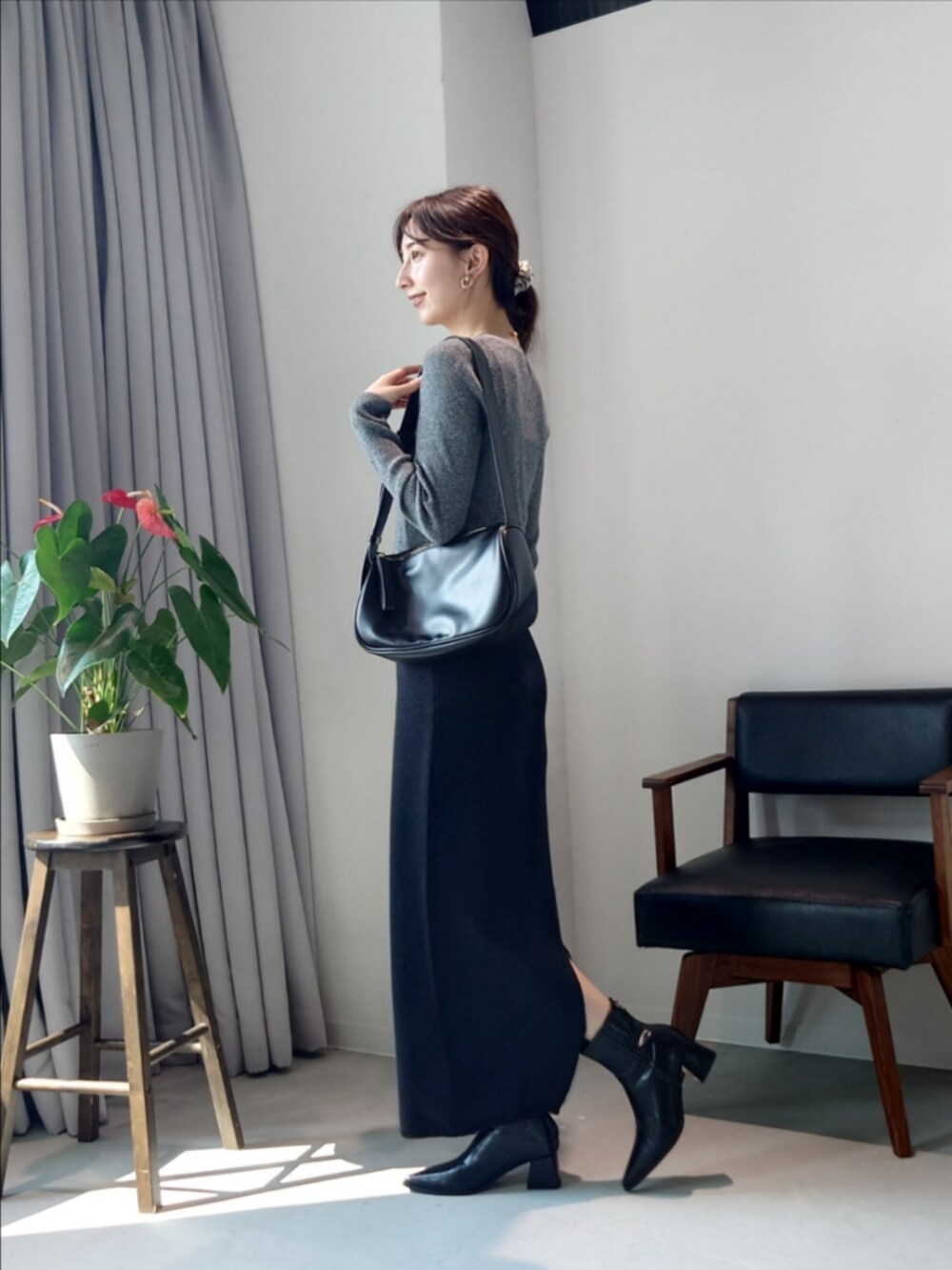 ブラック系のショルダーバッグ、グレー系のカーディガン/ボレロ、ブラック系のスカートを着用したレディースの秋コーディネートの2枚目の写真