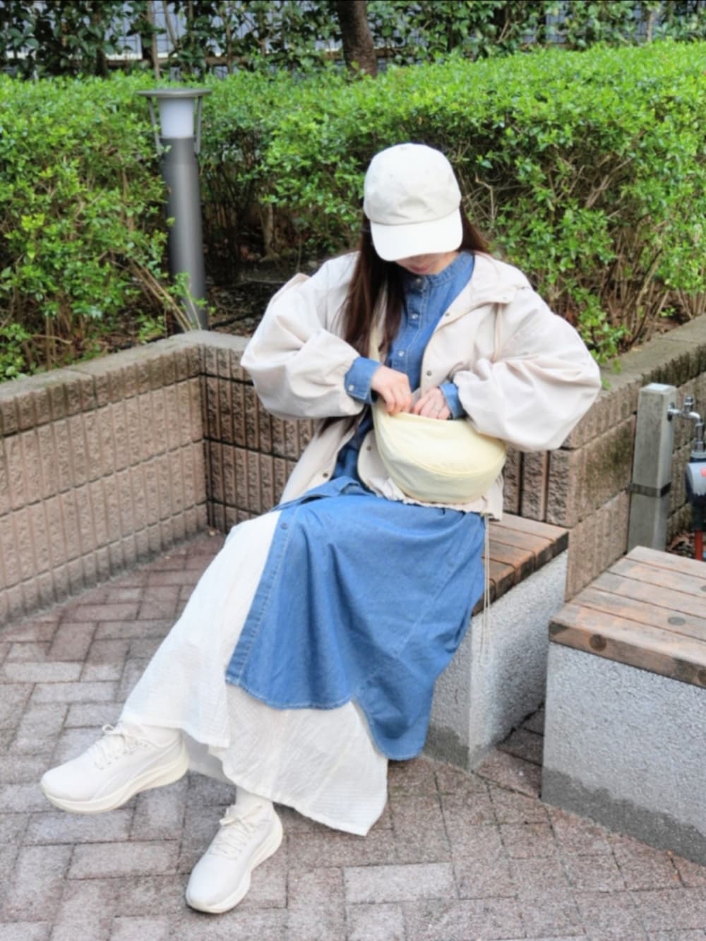 ブルー系のシャツワンピース、ホワイト系のマウンテンパーカー、ホワイト系のスカートを着用したレディースの春コーディネートの2枚目の写真