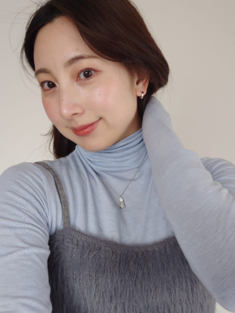 ブルー系のスラックス、グレー系のカーディガン/ボレロ、グレー系のベストを着用したレディースの冬コーディネートの3枚目の写真