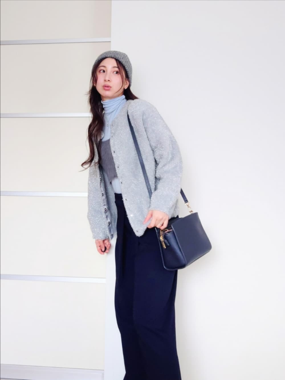 ブルー系のスラックス、グレー系のカーディガン/ボレロ、グレー系のベストを着用したレディースの冬コーディネートの4枚目の写真