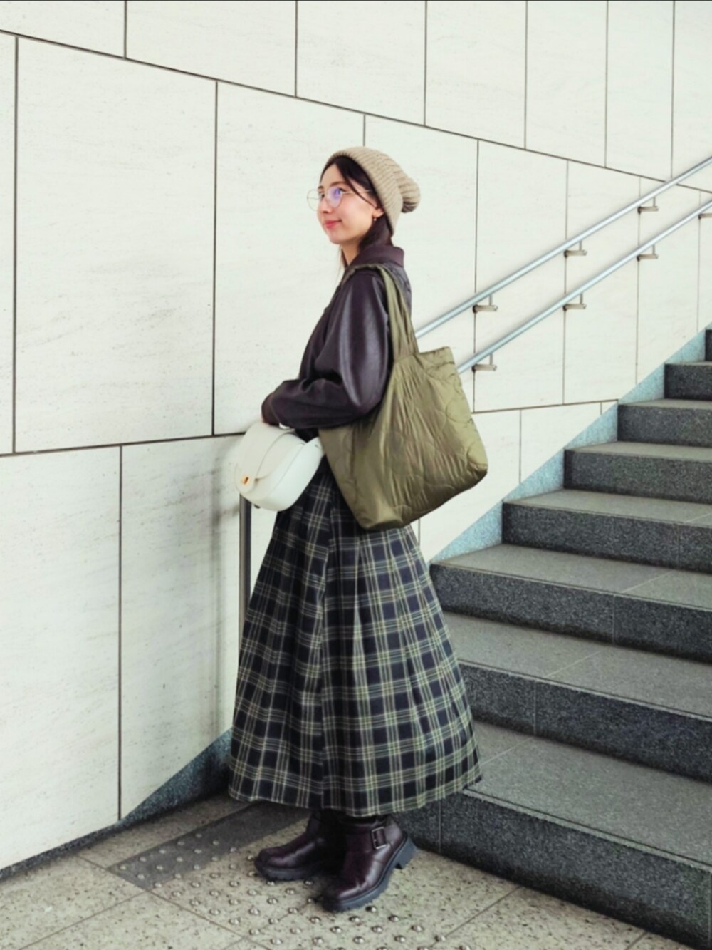 グリーン系のスカート、ホワイト系のショルダーバッグ、ブラウン系のノーカラージャケットを着用したレディースの秋コーディネートの3枚目の写真