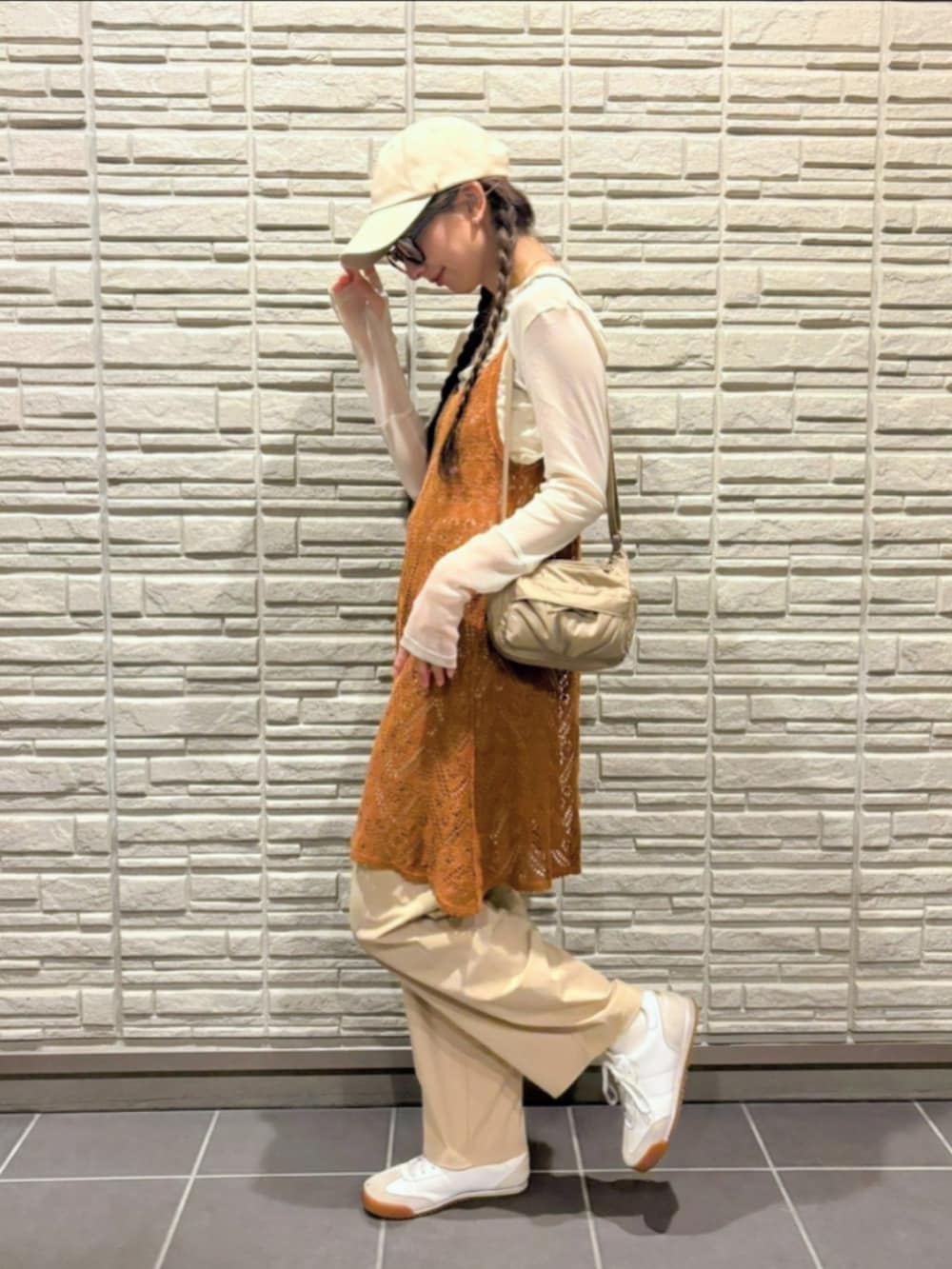 ベージュ系のスニーカー、ベージュ系のショルダーバッグ、ホワイト系のTシャツ/カットソーを着用したレディースの秋コーディネートの3枚目の写真