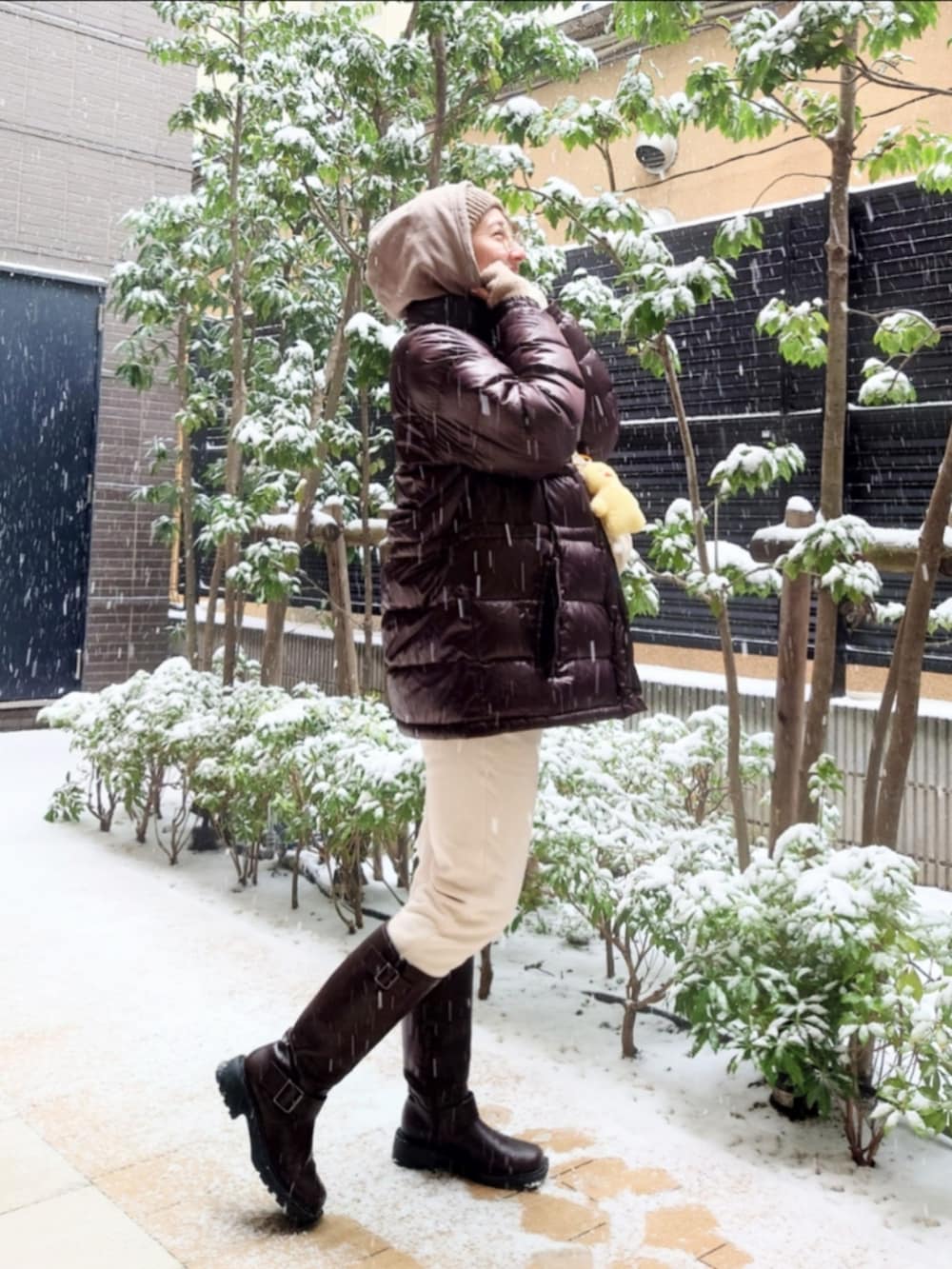 ブラウン系のブーツ、ブラウン系のパーカー、ブラウン系のダウンジャケット/コートを着用したレディースの冬コーディネートの2枚目の写真