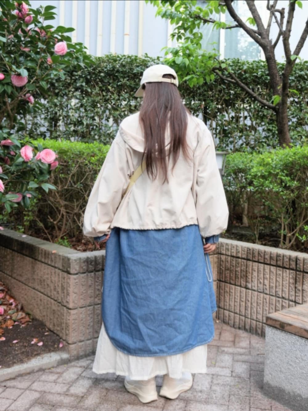 ブルー系のシャツワンピース、ホワイト系のマウンテンパーカー、ホワイト系のスカートを着用したレディースの春コーディネートの3枚目の写真