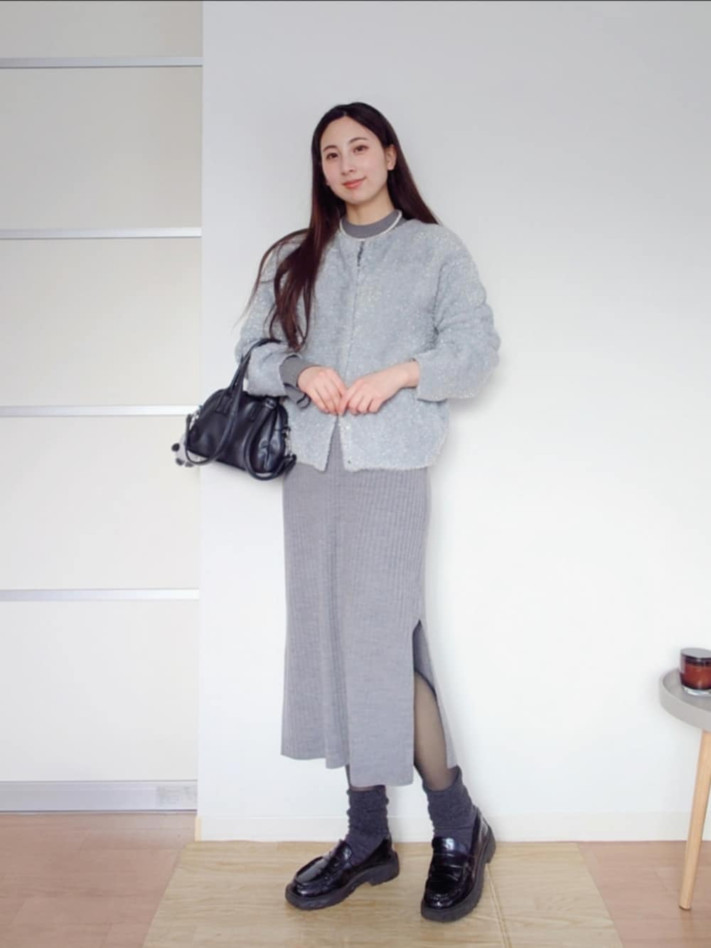 ブラック系のローファー、ブラック系のボストンバッグ、グレー系のカーディガン/ボレロを着用したレディースの春コーディネートの2枚目の写真