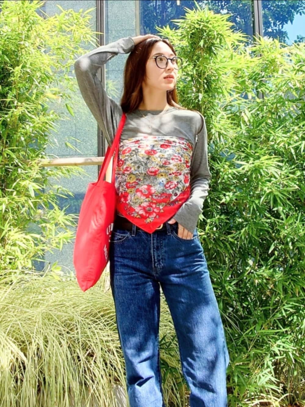 グレー系のTシャツ/カットソー、ブルー系のデニムパンツ、レッド系のトートバッグを着用したレディースの秋コーディネートの3枚目の写真