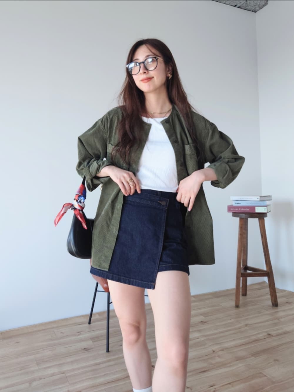 ブラック系のショルダーバッグ、ブルー系のその他パンツ、グリーン系のノーカラージャケットを着用したレディースの秋コーディネートの3枚目の写真