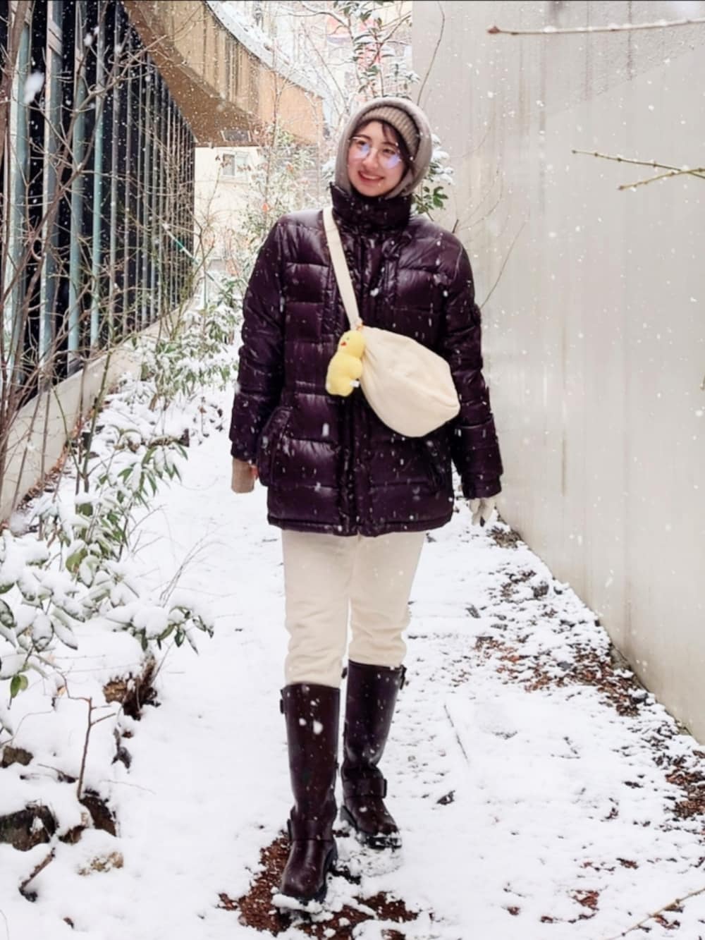 ブラウン系のブーツ、ブラウン系のパーカー、ブラウン系のダウンジャケット/コートを着用したレディースの冬コーディネートの3枚目の写真