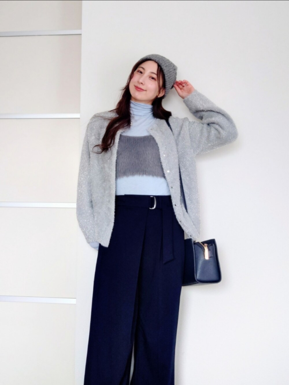 ブルー系のスラックス、グレー系のカーディガン/ボレロ、グレー系のベストを着用したレディースの冬コーディネートの2枚目の写真