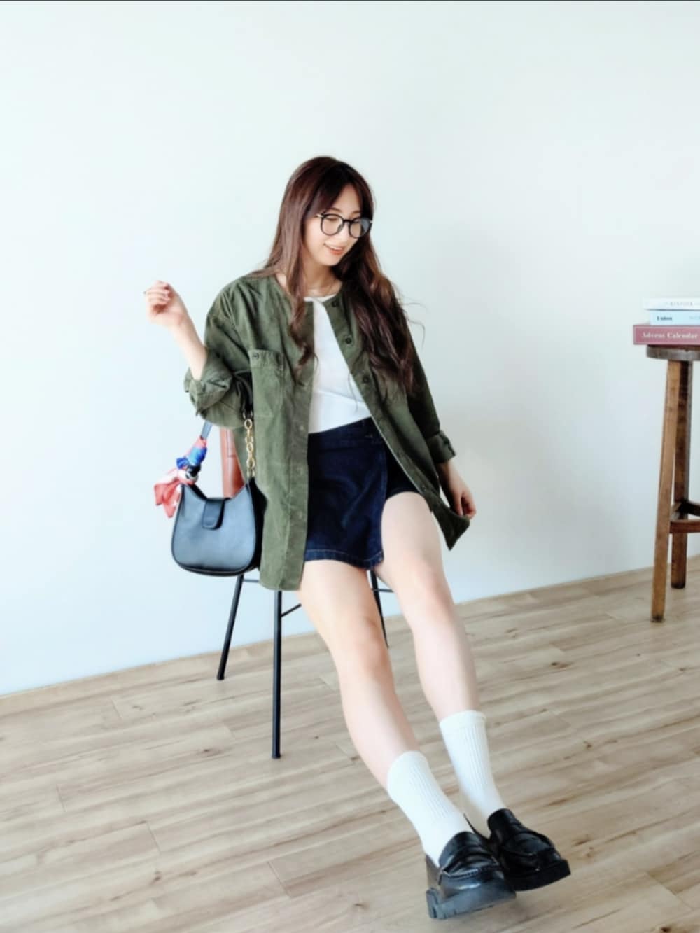 ブラック系のショルダーバッグ、ブルー系のその他パンツ、グリーン系のノーカラージャケットを着用したレディースの秋コーディネートの4枚目の写真