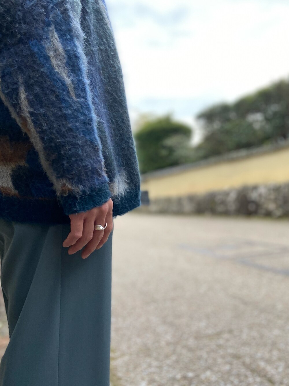 ブルー系のカーディガン/ボレロ、ブルー系のスラックス、ブラック系のブーツを着用したメンズの春コーディネートの2枚目の写真