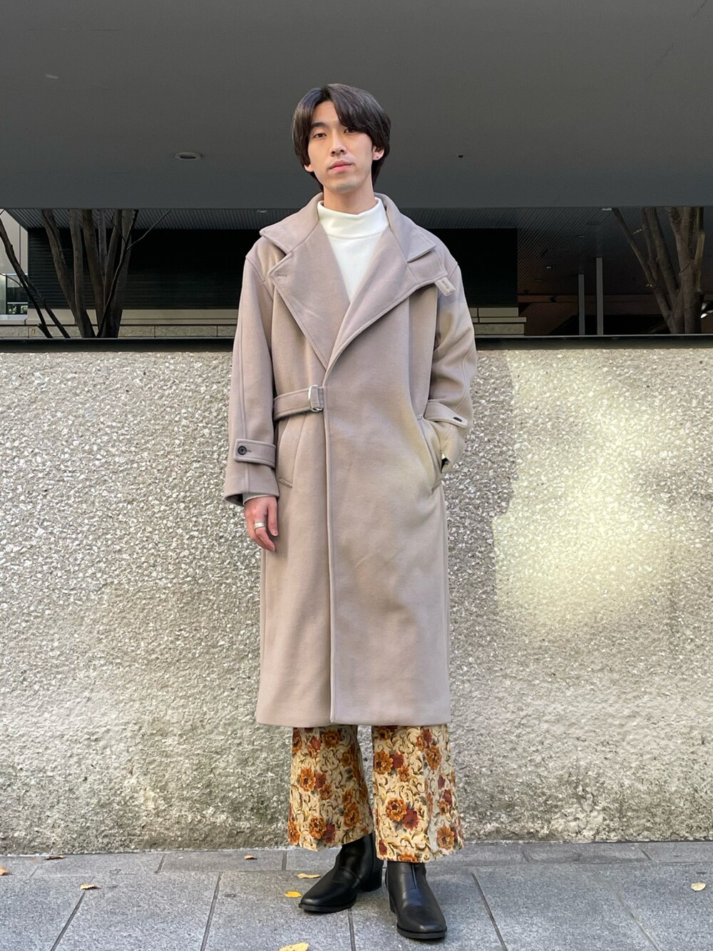 ホワイト系のニット/セーター、ベージュ系のチェスターコート、ベージュ系のその他パンツを着用したメンズの秋コーディネートの3枚目の写真