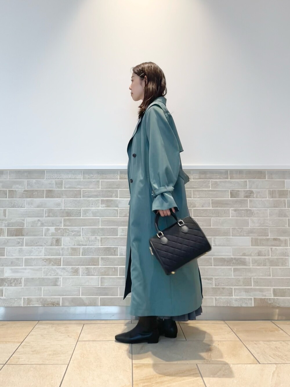 「テチチ(Te chichi)、トレンチコート、グリーン、Tシャツ、スカート、ブラック、通勤コーデ、秋コーデ」｜「Te chichiのキルティングボストンバック（ハンドバッグ、ブラック系）」を使った、m   aさん（レディース・162cm）の秋コーディネートの2枚目の写真