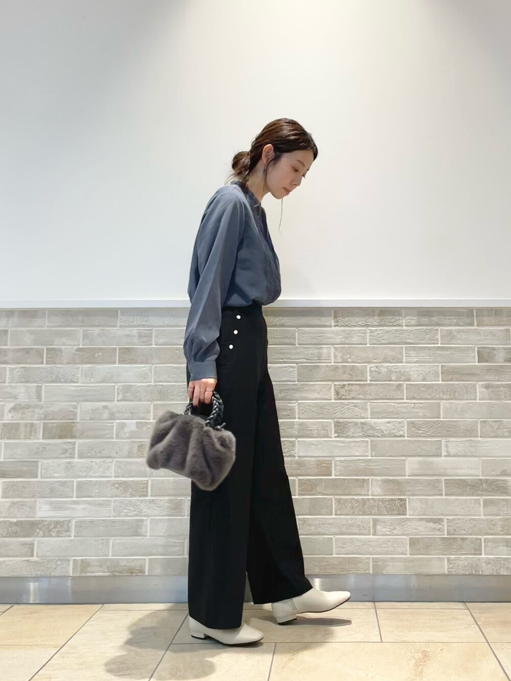 グレー系のハンドバッグ、ブラック系のその他パンツ、ホワイト系のブーツを着用したレディースの秋コーディネートの2枚目の写真