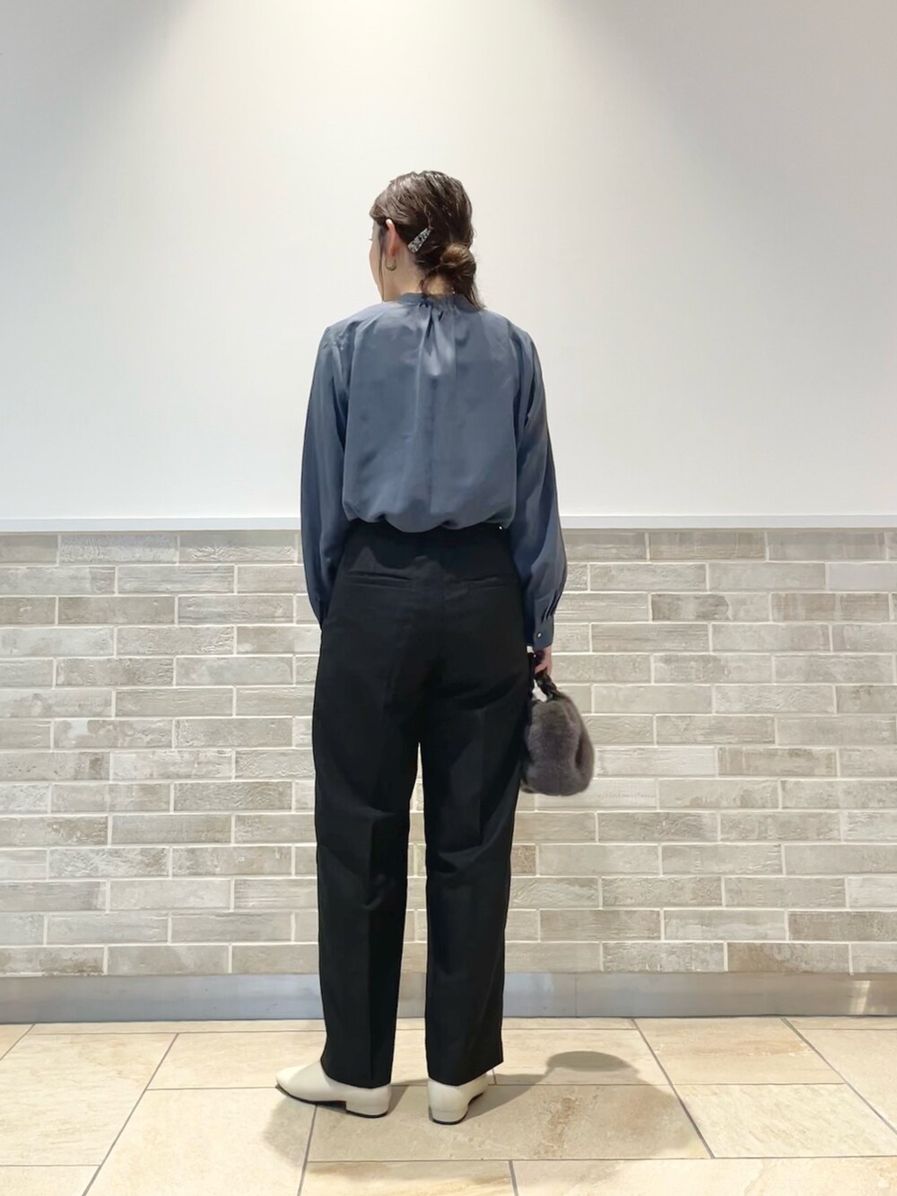 グレー系のハンドバッグ、ブラック系のその他パンツ、ホワイト系のブーツを着用したレディースの秋コーディネートの3枚目の写真