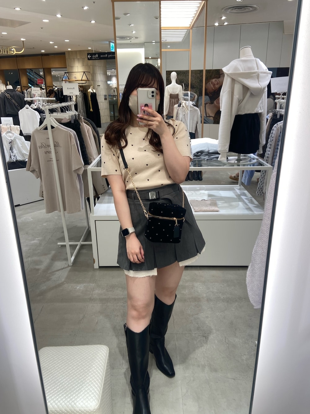 ベージュ系のニット/セーター、グレー系のスカート、ブラック系のショルダーバッグを着用したレディースの夏コーディネートの2枚目の写真