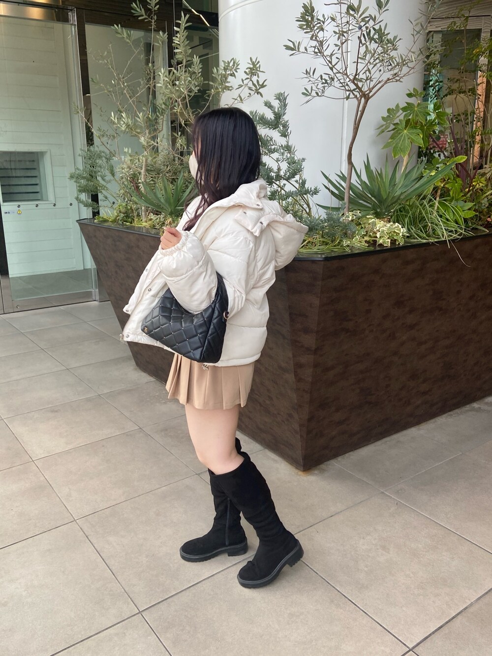 ホワイト系のダウンジャケット/コート、ホワイト系のニット/セーター、ベージュ系のスカートを着用したレディースの冬コーディネートの2枚目の写真