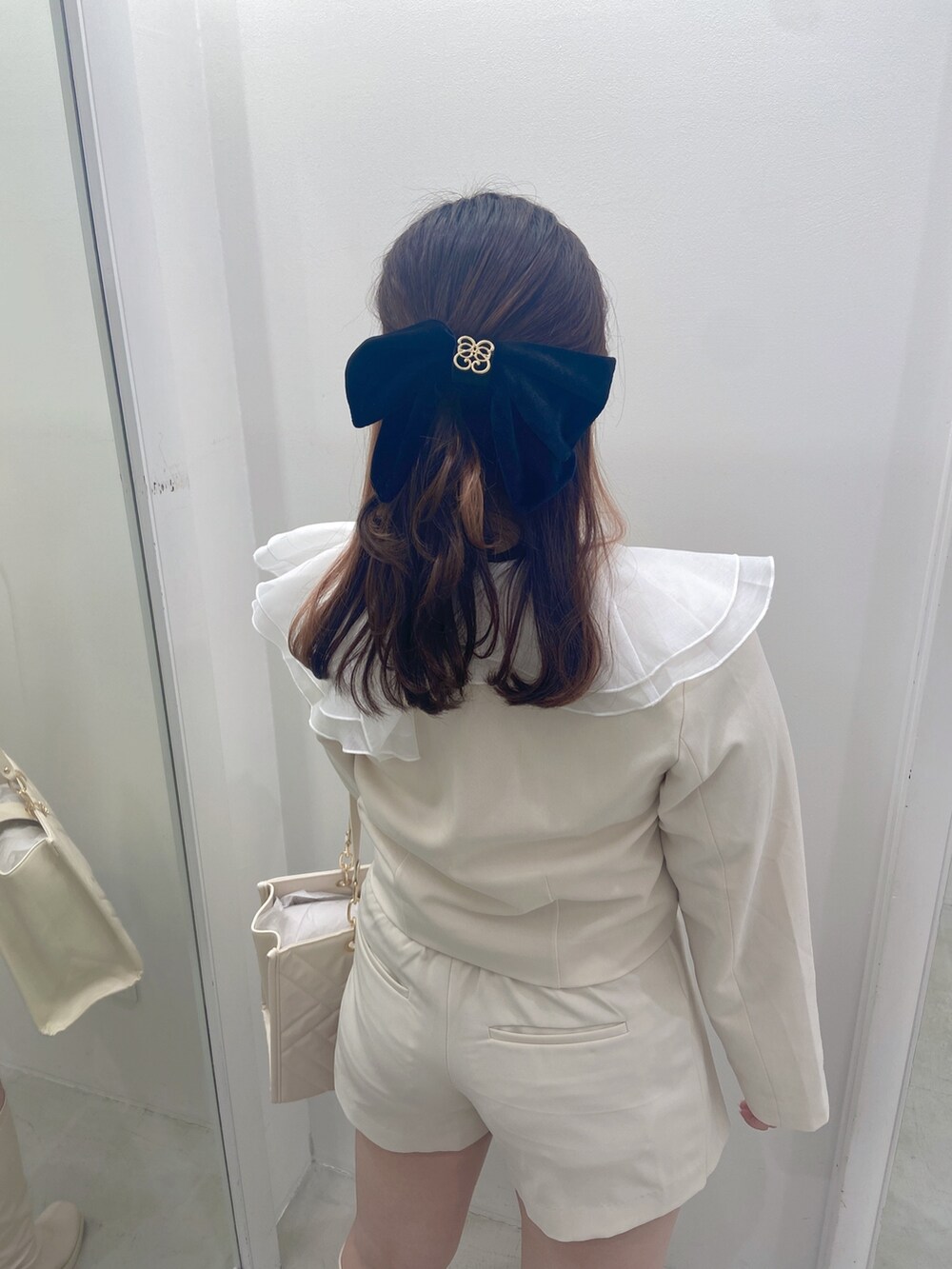 ホワイト系のノーカラージャケット、ホワイト系のその他パンツを着用したレディースの冬コーディネートの2枚目の写真