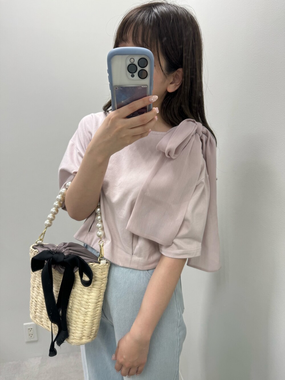 ピンク系のTシャツ/カットソー、ブラック系のかごバッグ、ブルー系のデニムパンツを着用したレディースの春コーディネートの3枚目の写真