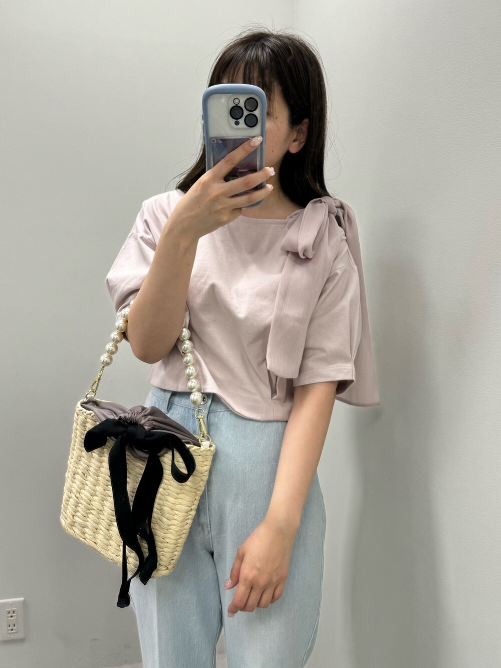 ピンク系のTシャツ/カットソー、ブラック系のかごバッグ、ブルー系のデニムパンツを着用したレディースの春コーディネートの2枚目の写真