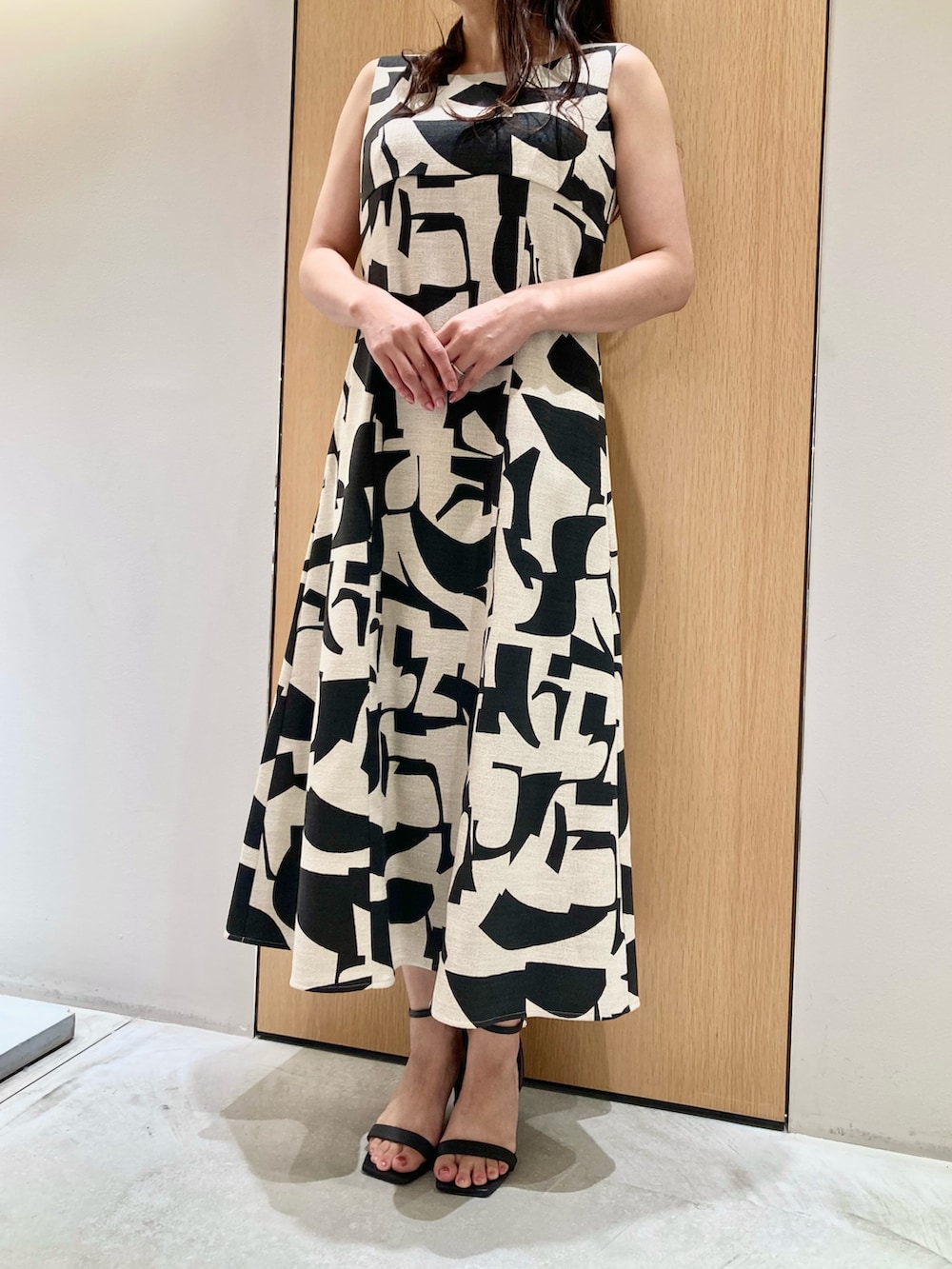 ベージュ系のワンピース、ゴールド系のイヤリングを着用したレディースの夏コーディネートの4枚目の写真