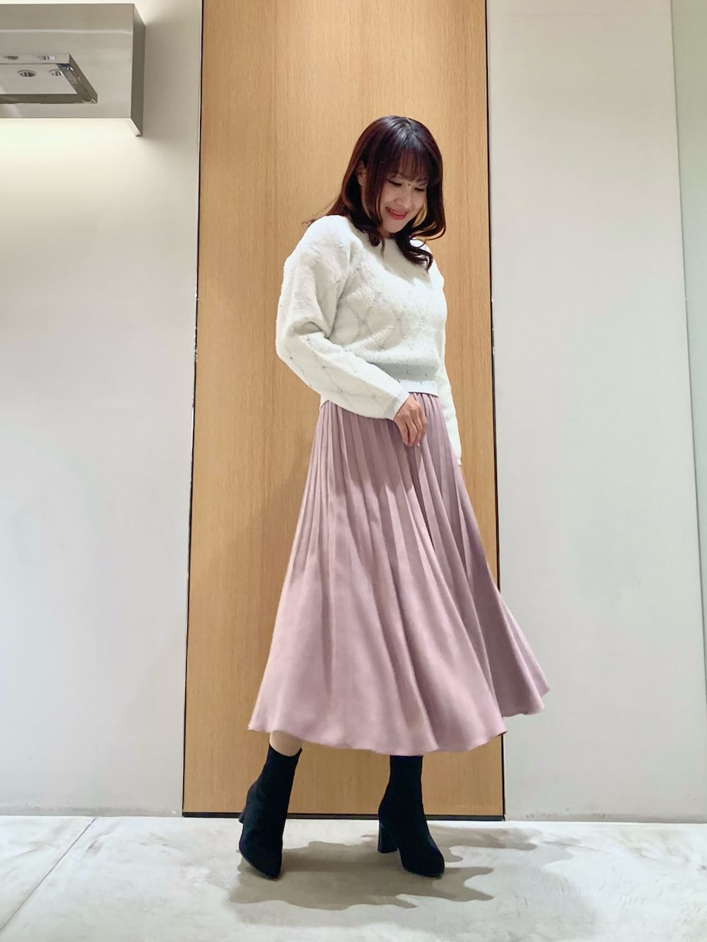 ホワイト系のニット/セーター、ピンク系のスカートを着用したレディースの冬コーディネートの2枚目の写真